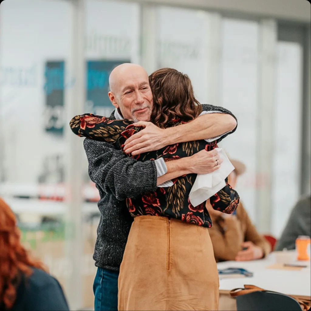 Two people sharing a hug at a Common Trust event