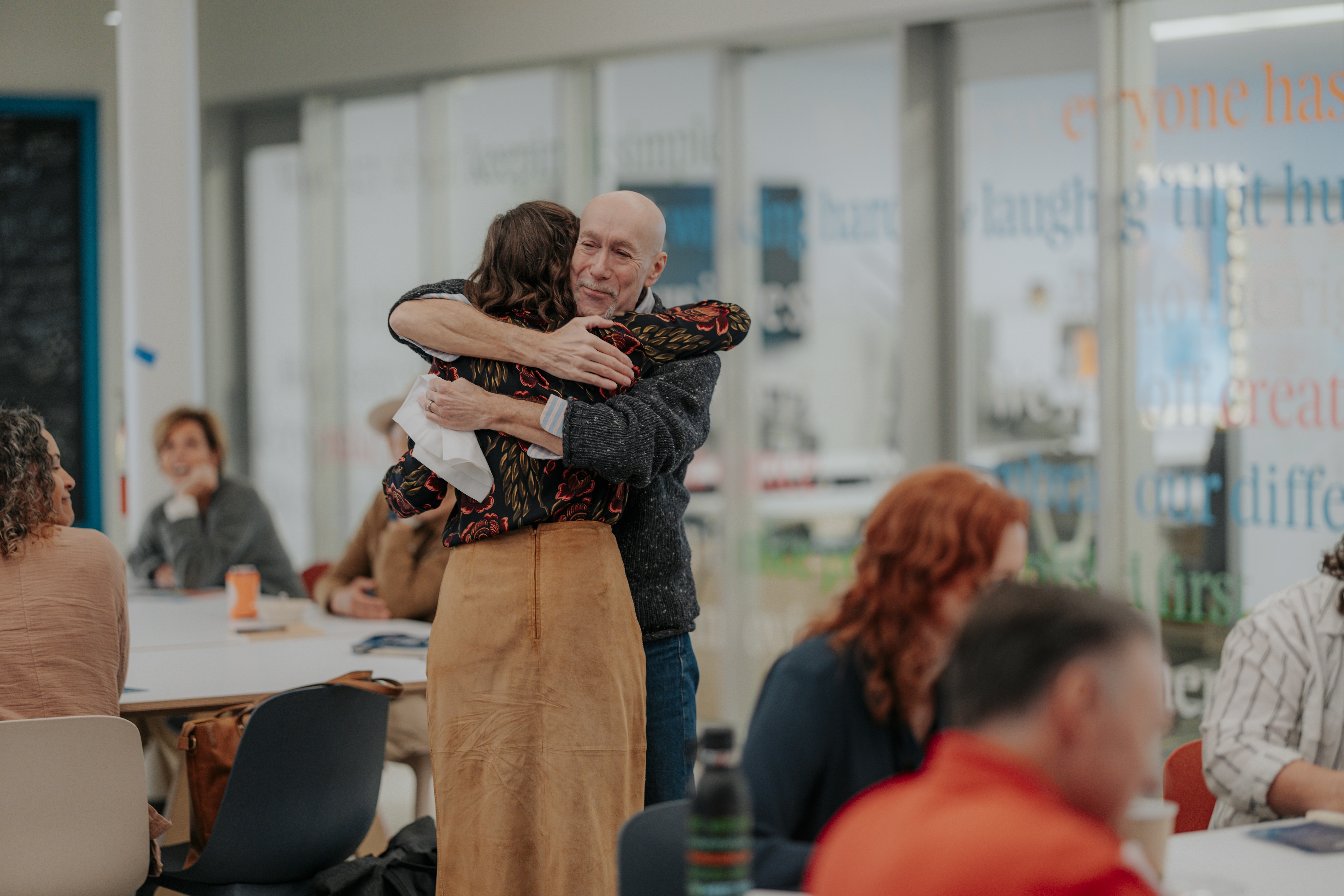 Two people sharing a hug at a Common Trust event